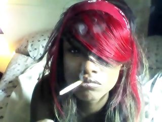 Black girl smoking in bed watching tv