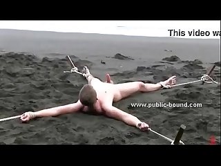 A guy is tied, exposed and abused at the beach by gay tops
